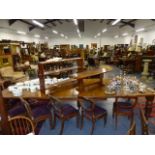 A LARGE VICTORIAN OAK EXTENDING DINING TABLE STANDING ON FIVE STOUT TURNED LEGS AND CASTORS COMPLETE