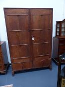 AN ANTIQUE ARTS AND CRAFTS COTSWOLD SCHOOL OAK TWO DOOR WARDROBE. W.122 x H.182.5cms.