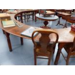 A LARGE ANTIQUE OAK LIBRARY TABLE OF HORSESHOE FORM WITH BRASS INSET INKWELLS STANDING ON TURNED