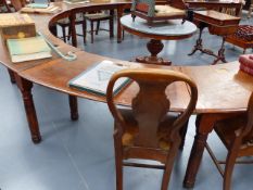 A LARGE ANTIQUE OAK LIBRARY TABLE OF HORSESHOE FORM WITH BRASS INSET INKWELLS STANDING ON TURNED