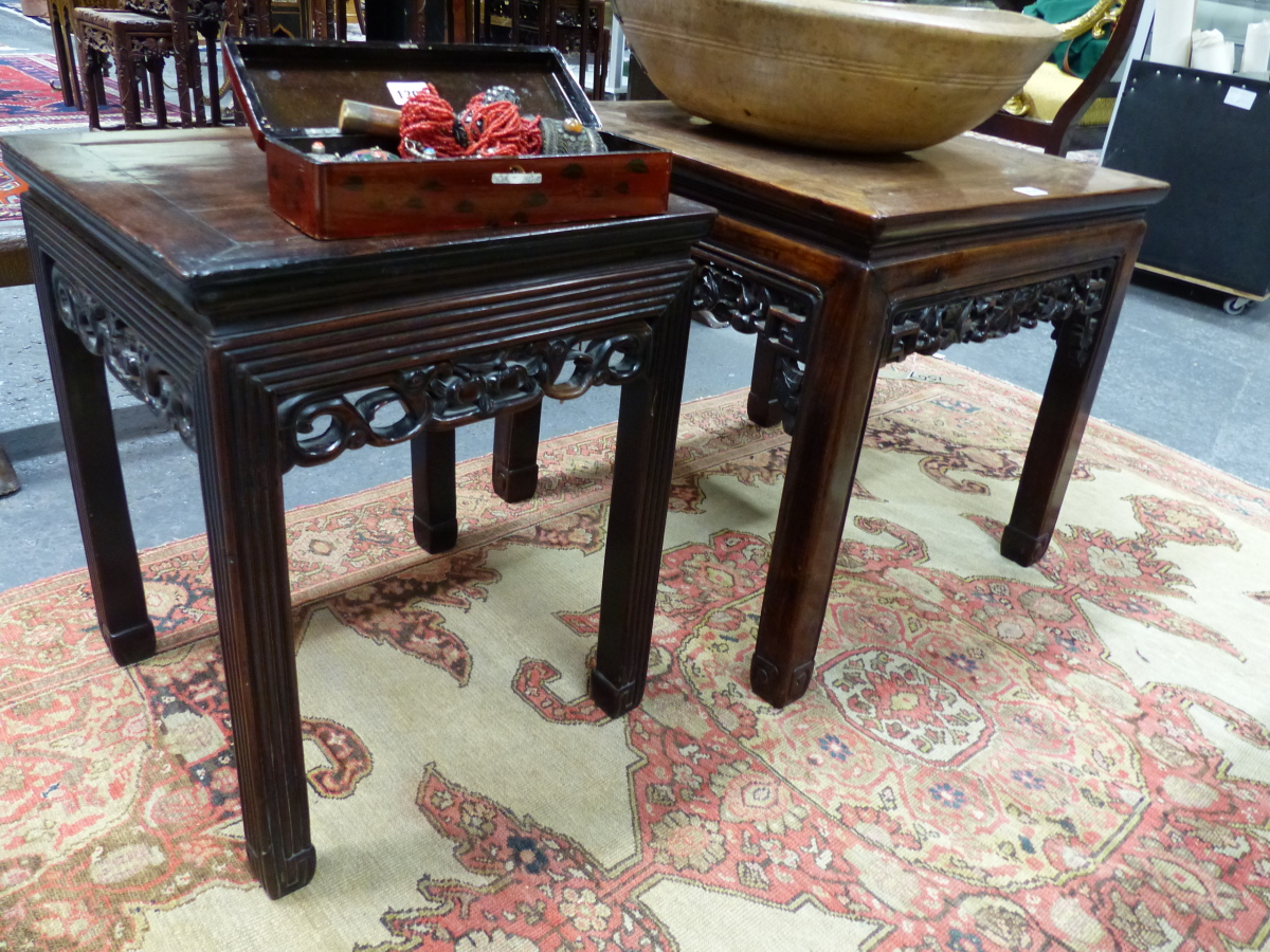 TWO CHINESE CARVED HARDWOOD SQUARE STANDS WITH PIERCED FOLIATE APRONS AND MOULDED STRAIGHT LEGS.