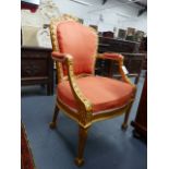 A CARVED GILTWOOD GEORGIAN ARMCHAIR OF NEOCLASSICAL DESIGN WITH BOWKNOT CREST , HUSK DECORATED FRAME