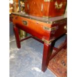 A BRASS BOUND MAHOGANY SQUARE CAMPAIGN STYLE BIJOUTERIE TABLE WITH GLAZED TOP AND BRASS CARRYING