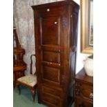 AN ANTIQUE ENGLISH OAK NARROW FLOORSTANDING CUPBOARD OF PANEL CONSTRUCTION, THE CUPBOARD DOOR