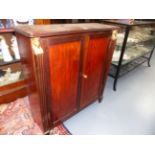A CARVED MAHOGANY TWO DOOR DWARF CABINET IN THE REGENCY EGYPTIAN REVIVAL STYLE. H.80 x W.74cms.
