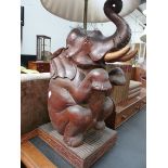 A PAIR OF EASTERN CARVED HARDWOOD FIGURES OF SEATED ELEPHANTS NOW MOUNTED AS LAMPS. OVERALL H.