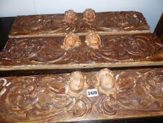 THREE EARLY CARVED AND GILT CONTINENTAL FRIEZE PANELS OF ANGEL MASKS AND SCROLLWORK.