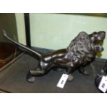 A JAPANESE BRONZE FIGURE OF A ROARING LION, SIGNED WITH SEAL TABLET TO BASE. L.51cms.