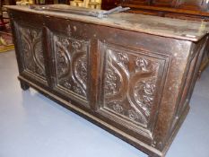 AN 18th.C.OAK COFFER WITH THREE PANEL FRONT INCORPORATING EARLIER CARVED PANELS. W.141cms.