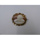 AN OVAL CARVED CAMEO BROOCH DEPICTING A GAZING CHERUB MOUNTED IN PRECIOUS YELLOW METAL TESTED AS