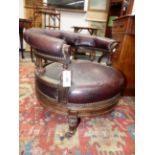 AN UNUSUAL VICTORIAN CARVED ROSEWOOD REVOLVING LOW SALON ARMCHAIR IN NAILED BROWN LEATHER,