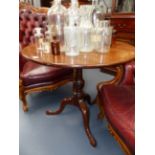 A GEORGIAN MAHOGANY CIRCULAR TILT TOP LAMP TABLE WITH TRIFID SCROLL LEGS ENDING IN PAD FEET. D.