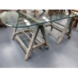 A PAIR OF ANTIQUE DECORATOR'S TRESTLES NOW MOUNTED WITH PLATE GLASS BEVEL EDGE TOP.