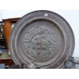 AN ANTIQUE EMBOSSED BRASS LARGE CHARGER WITH ARMORIAL CENTRE. D.64cms.