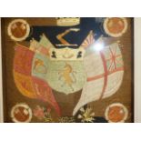 AN ANTIQUE SILKWORK PANEL OF AN ARMORIAL CREST SURROUNDED BY FLAGS IN BESPOKE SHADOW BOX FRAME. 42 x