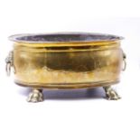 A 19th.C.BRASS OVAL JARDINIERE/COOLER WITH LION MASK HANDLES, PAW FEET AND TOLE LINER. W.36cms.