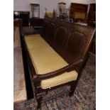 A GEO.III.COUNTRY OAK HALL SETTLE WITH PANEL BACK STANDING ON STOUT CABRIOLE LEGS. W.182cms.