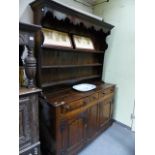 A GOOD EARLY 18th.C.AND LATER OAK DRESSER BASE WITH THREE DRAWERS AND SHAPED PANEL DOORS AND WITH