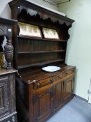 A GOOD EARLY 18th.C.AND LATER OAK DRESSER BASE WITH THREE DRAWERS AND SHAPED PANEL DOORS AND WITH