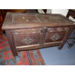 AN 18th.C.OAK TWO PANELLED COFFER WITH CARVED DECORATION. W.101cms.