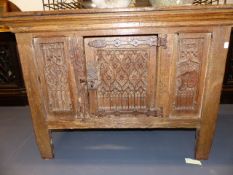 A 17th.C.OAK LOW CUPBOARD WITH GOTHIC CARVED PANELS AND IRON STRAP HINGES. W.104cms.