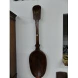 AN UNUSUAL CARVED PINE FOLK ART LARGE WOODEN SPOON, POSSIBLY A CUTLER'S SIGN. L.156cms (APPROX)