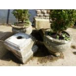 A PAIR OF CARVED STONE CIRCULAR GARDEN URNS ON ASSOCIATED PLINTH BASES.
