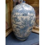 A LARGE CHINESE PROVINCIAL POTTERY OVOID FORM JAR AND COVER DECORATED IN BLUE WITH PANELS OF