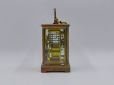 AN EARLY 20th.C.BRASS CASED CARRIAGE CLOCK WITH TWO TRAIN GONG STRIKE MOVEMENT, WHITE ENAMEL DIAL