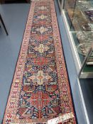 AN ORIENTAL RUNNER OF CAUCASIAN DESIGN. 358x78cms.