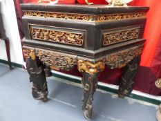 A CHINESE GILT AND EBONISED CARVED ALTAR TABLE WITH SHAPED TOP ABOVE PANELLED FRIEZE SCROLL LEGS.