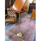 A VICTORIAN BRASS AND OAK ADJUSTABLE MUSIC STAND WITH TRIFID SCROLL FEET.