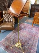 A VICTORIAN BRASS AND OAK ADJUSTABLE MUSIC STAND WITH TRIFID SCROLL FEET.