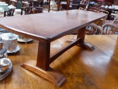 A COTSWOLD SCHOOL WALNUT BENCH/LOW TABLE WITH TRESTLE ENDS JOINED BY MEDIAL STRETCHER. H.39 x W.