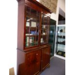 A LATE GEORGIAN MAHOGANY BOOKCASE CABINET WITH GLAZED DOORS OVER PANEL DOOR BASE. W.128 x H.222cms.