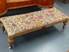 A VICTORIAN GILT FRAMED LONG STOOL WITH TAPESTRY TOP. L.118cms x W.49cms.