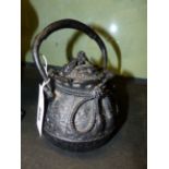 A JAPANESE CEREMONIAL IRON TEAPOT OF GLOBULAR FORM WITH BROCADE TIES AND KNOTS. H.OVER HANDLE