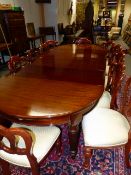 A GOOD LATE VICTORIAN MAHOGANY WIND OUT EXTENDING DINING TABLE ON TURNED AND CARVED LEGS WITH CAS