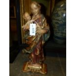 A CONTINENTAL CARVED AND POLYCHROME STANDING FIGURAL GROUP OF THE MADONNA AND CHILD WITH GILT