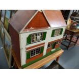 A LARGE DOLL'S HOUSE ON A PINE TABLE BASE.