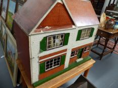 A LARGE DOLL'S HOUSE ON A PINE TABLE BASE.