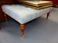 A BUTTON UPHOLSTERED MAHOGANY REGENCY STYLE LARGE STOOL WITH BRASS CASTORS. W.104cms.