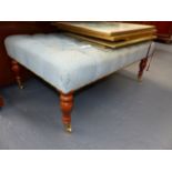 A BUTTON UPHOLSTERED MAHOGANY REGENCY STYLE LARGE STOOL WITH BRASS CASTORS. W.104cms.