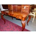 A CARVED MAHOGANY VICTORIAN SERPENTINE FORM WRITING/SIDE TABLE, SHELVED AND MULTI DRAWER