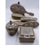 SEVEN ASIAN WHITE METAL DRESSING TABLE PIECES EACH WITH FIGURAL DECORATION TO INCLUDE A HAND MIRROR,