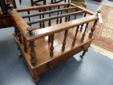 A VICTORIAN ROSEWOOD THREE DIVISION CANTERBURY WITH APRON DRAWER ON TURNED LEGS ENDING IN CERAMIC