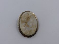 A WHITE CARVED PORTRAIT CAMEO SET IN A SILVER STAMPED FLUTED BROOCH MOUNT. APPROXIMATE