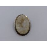 A WHITE CARVED PORTRAIT CAMEO SET IN A SILVER STAMPED FLUTED BROOCH MOUNT. APPROXIMATE