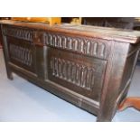 A 17th/18th.C. OAK COFFER WITH LOZENGE CARVED PANEL FRONT AND FRIEZE. W.125cms.