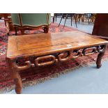 A CARVED CHINESE LOW TABLE OF RECTANGULAR FORM WITH PIERCED SCROLLWORK APRON. H.28 W.76cms.